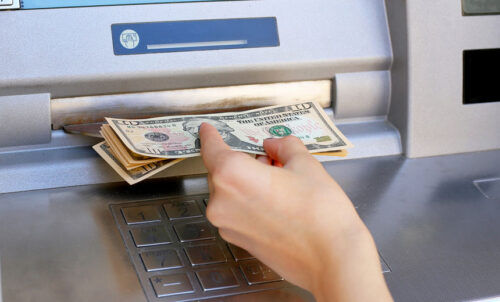 Person removing money from an ATM.